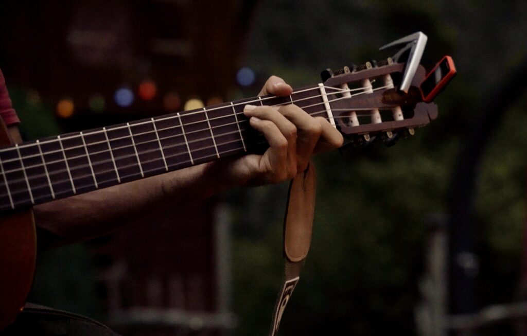 Guitar neck with left hand grabbing a chord